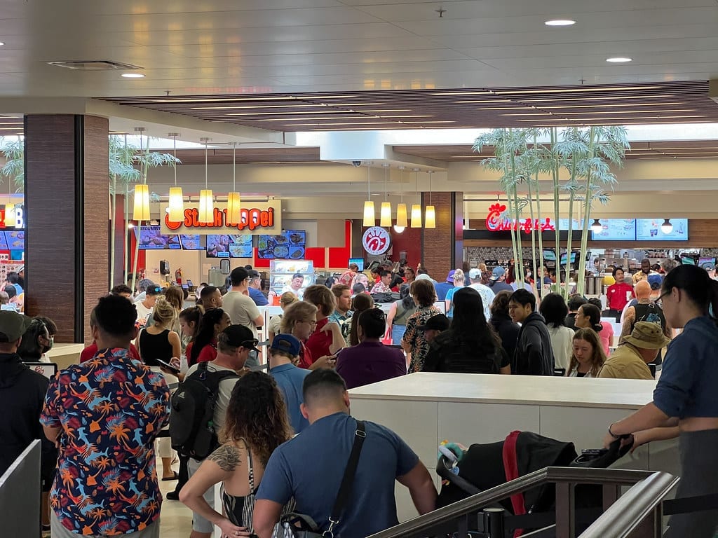 Customers lined up at a Chick-fil-A counter inside a shopping mall
