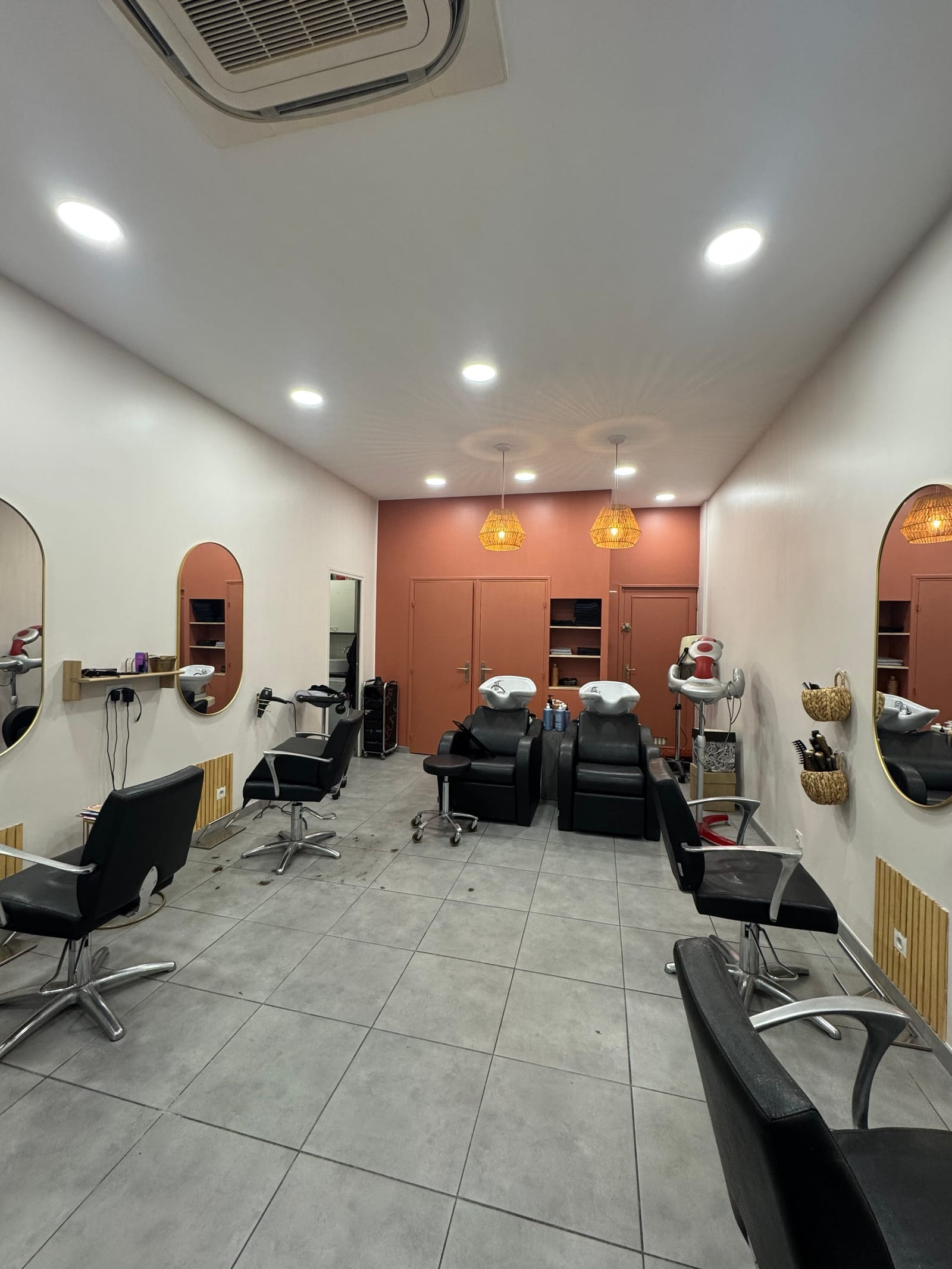 Hair salon interior with a row of styling chairs and wall mirrors