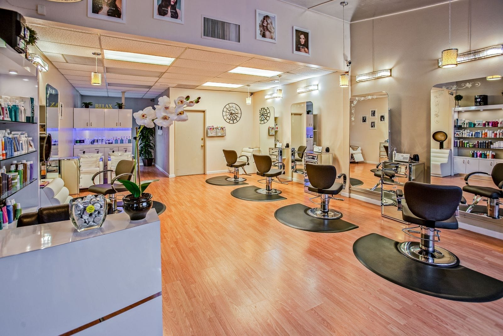 Row of salon styling stations with chairs and vanity mirrors in a modern hair salon