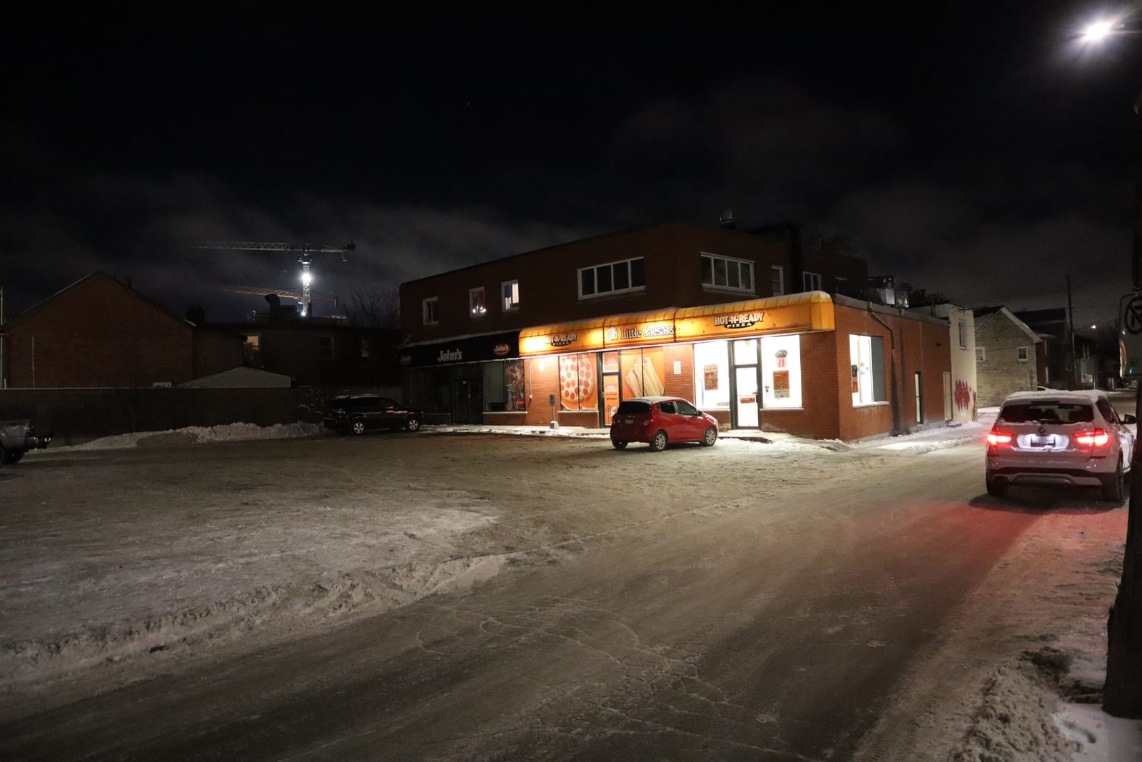 Little Caesars storefront exterior at night with illuminated Hot-N-Ready Pizza signage