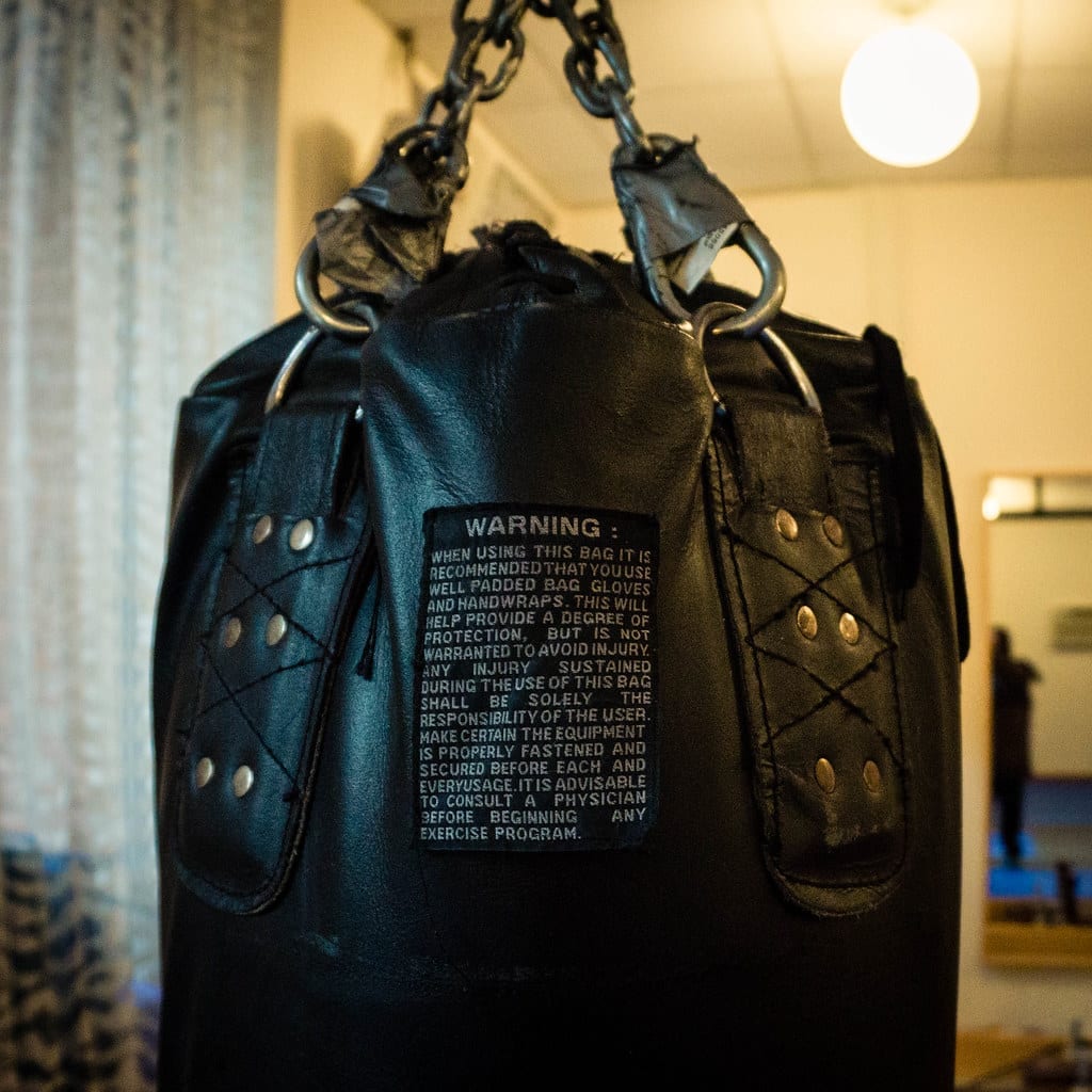 Close-up of a leather heavy bag hanging from a chain inside a gym