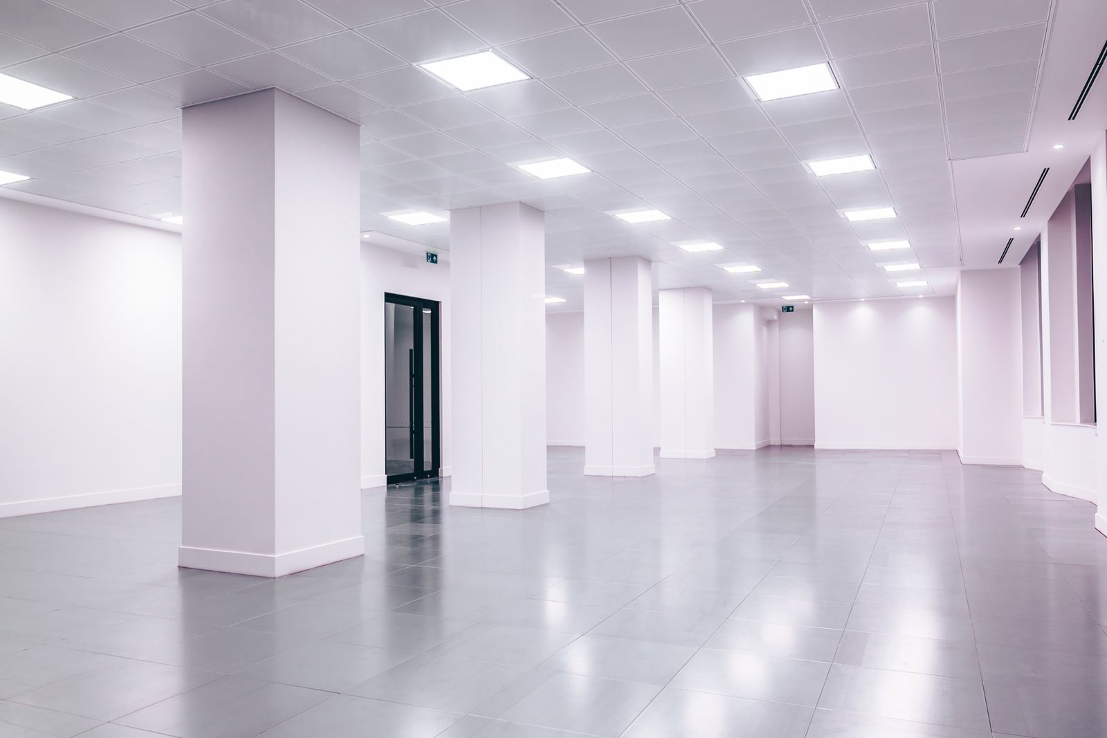 A clean, near-empty white office interior with bright overhead lighting