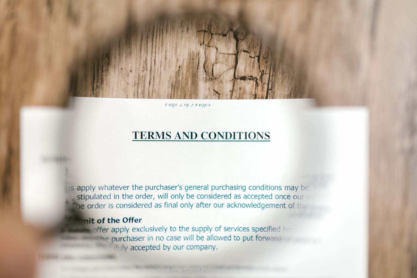 A 'Terms and Conditions' heading on a printed page, viewed through a magnifying glass