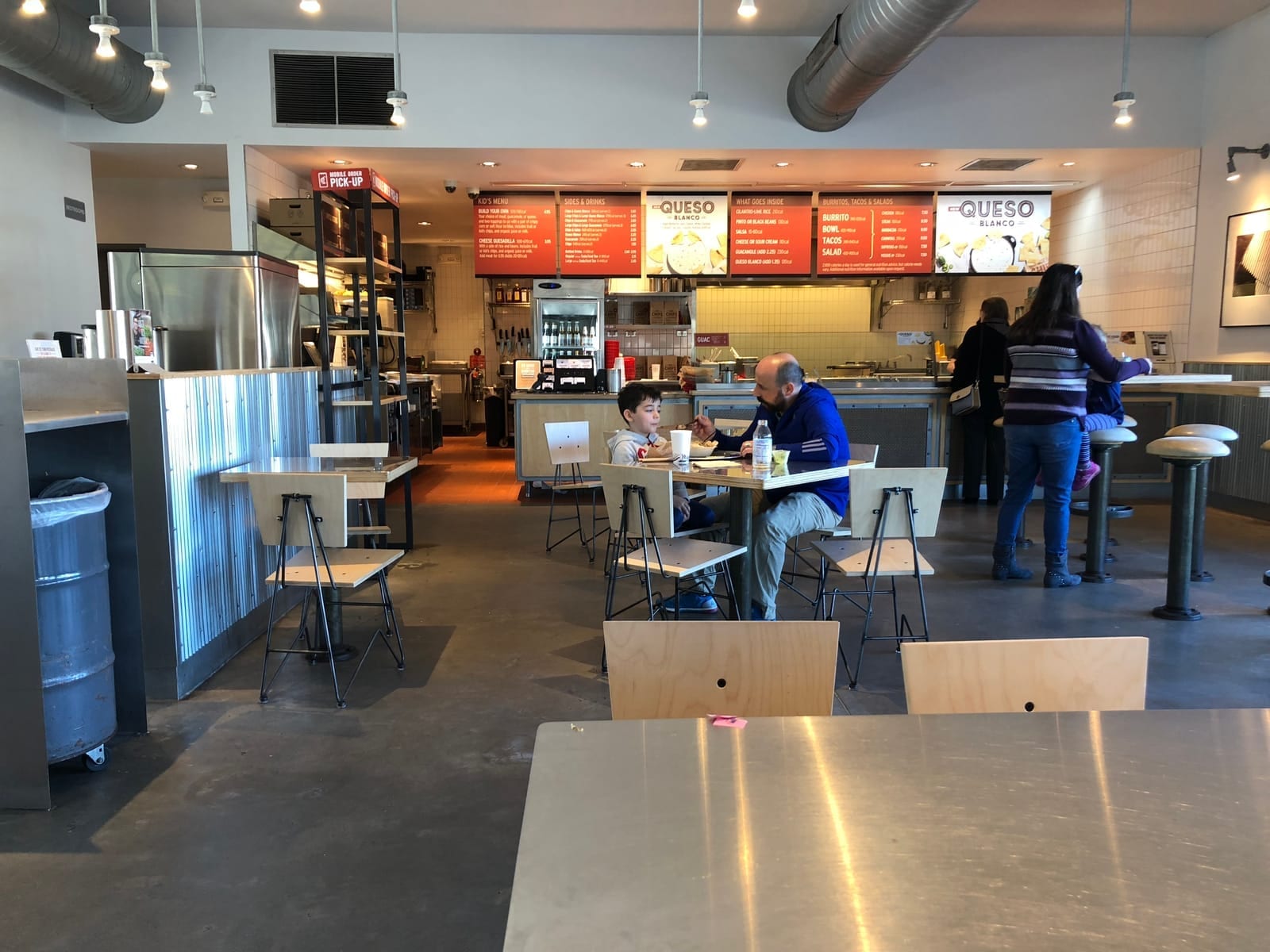 Interior of a Chipotle restaurant showing the ordering counter, menu boards, and dining tables