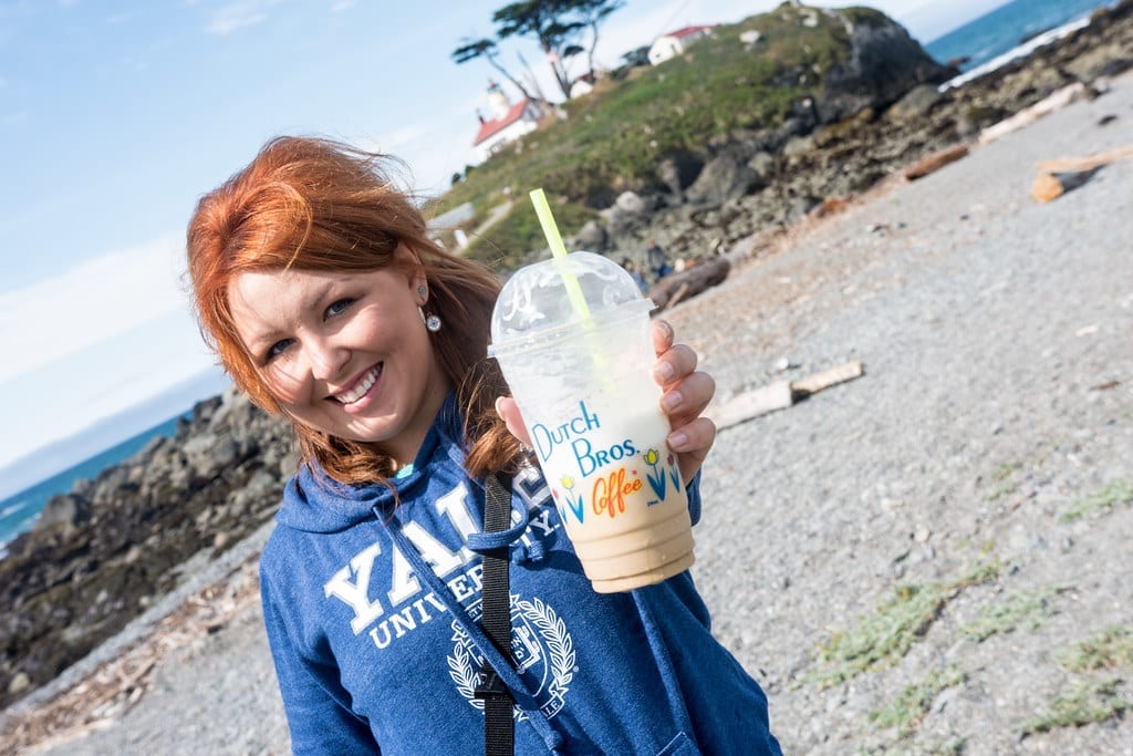 A person holding an iced Dutch Bros Coffee drink in a branded cup