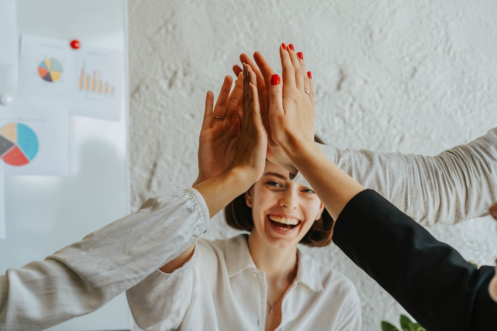 Coworkers high-fiving in a workplace setting