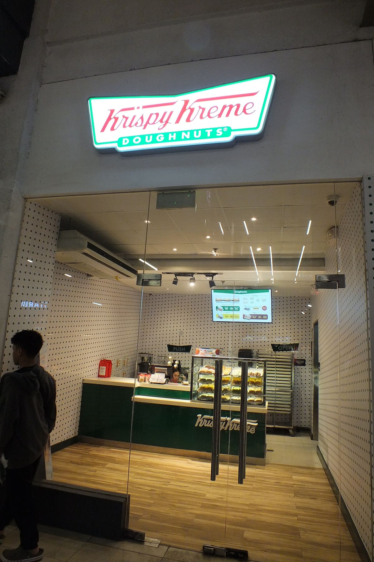 Krispy Kreme kiosk storefront with an illuminated sign inside Mactan-Cebu International Airport in the Philippines